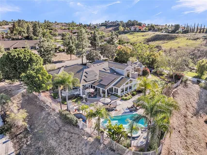 an aerial view of residential houses with outdoor space and trees all around