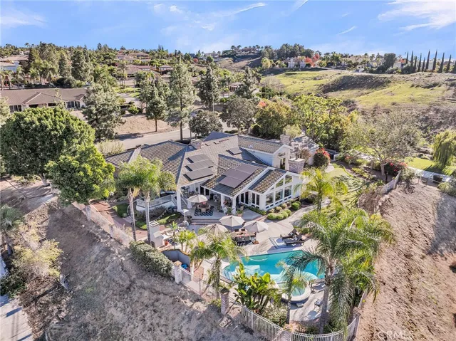 an aerial view of residential houses with outdoor space and trees all around