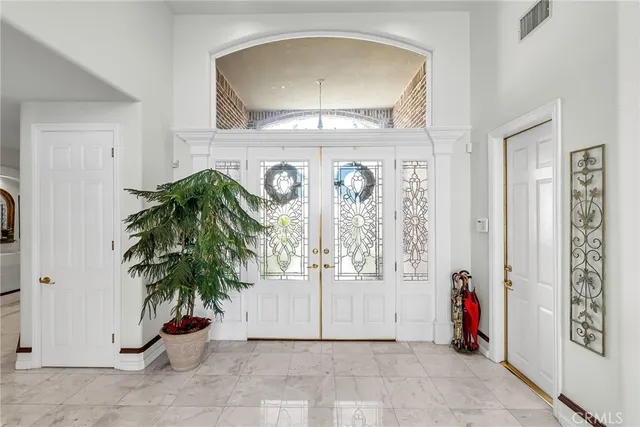 an entryway with wooden floor and a potted plant