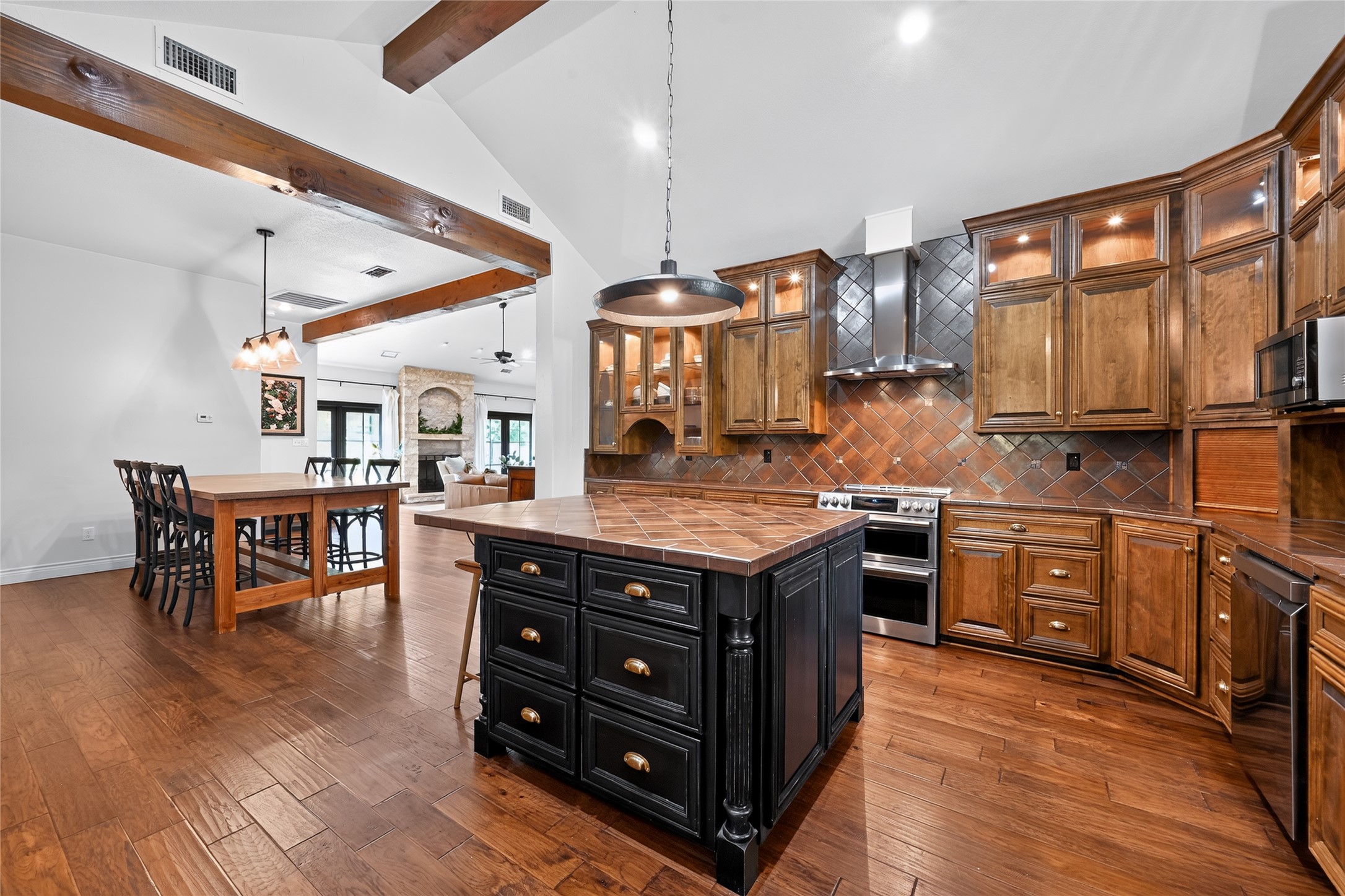 700 Willow Creek Road Salado, TX 76571 - Photo 7 of 39 Kitchen positioned just off the main living area featuring induction cooktop, double oven, custom cabinetry, and updated lighting.