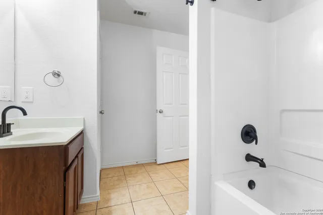 an empty room with a ceiling fan and wooden floor