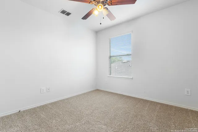 an empty room with a chandelier fan