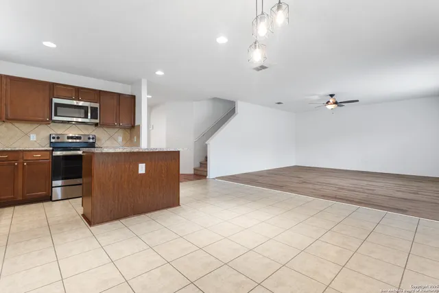 a kitchen with stainless steel appliances granite countertop a refrigerator and a sink