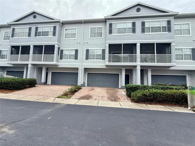 a front view of a building with a yard and plants