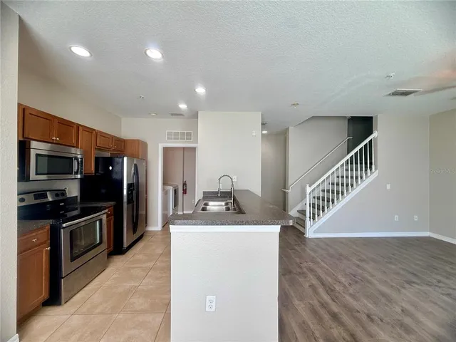 a view of kitchen with sink microwave and refrigerator