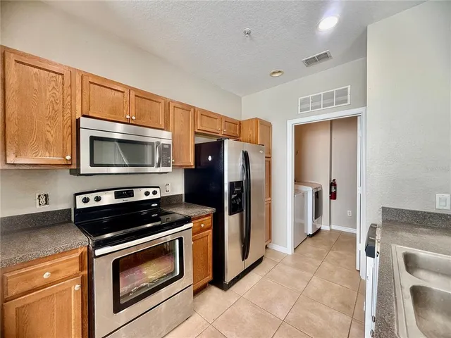 a kitchen with stainless steel appliances a stove a microwave and a refrigerator