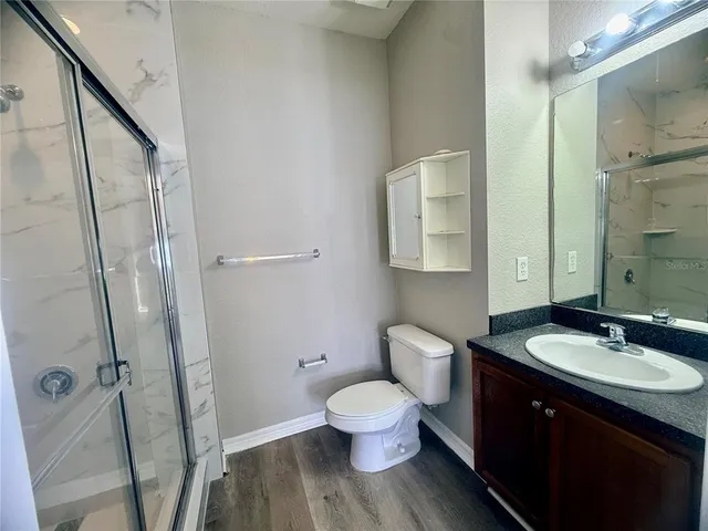 a bathroom with a sink toilet a mirror and shower