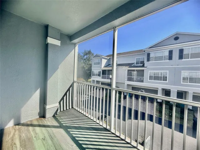 a view of a balcony with wooden floor and fence