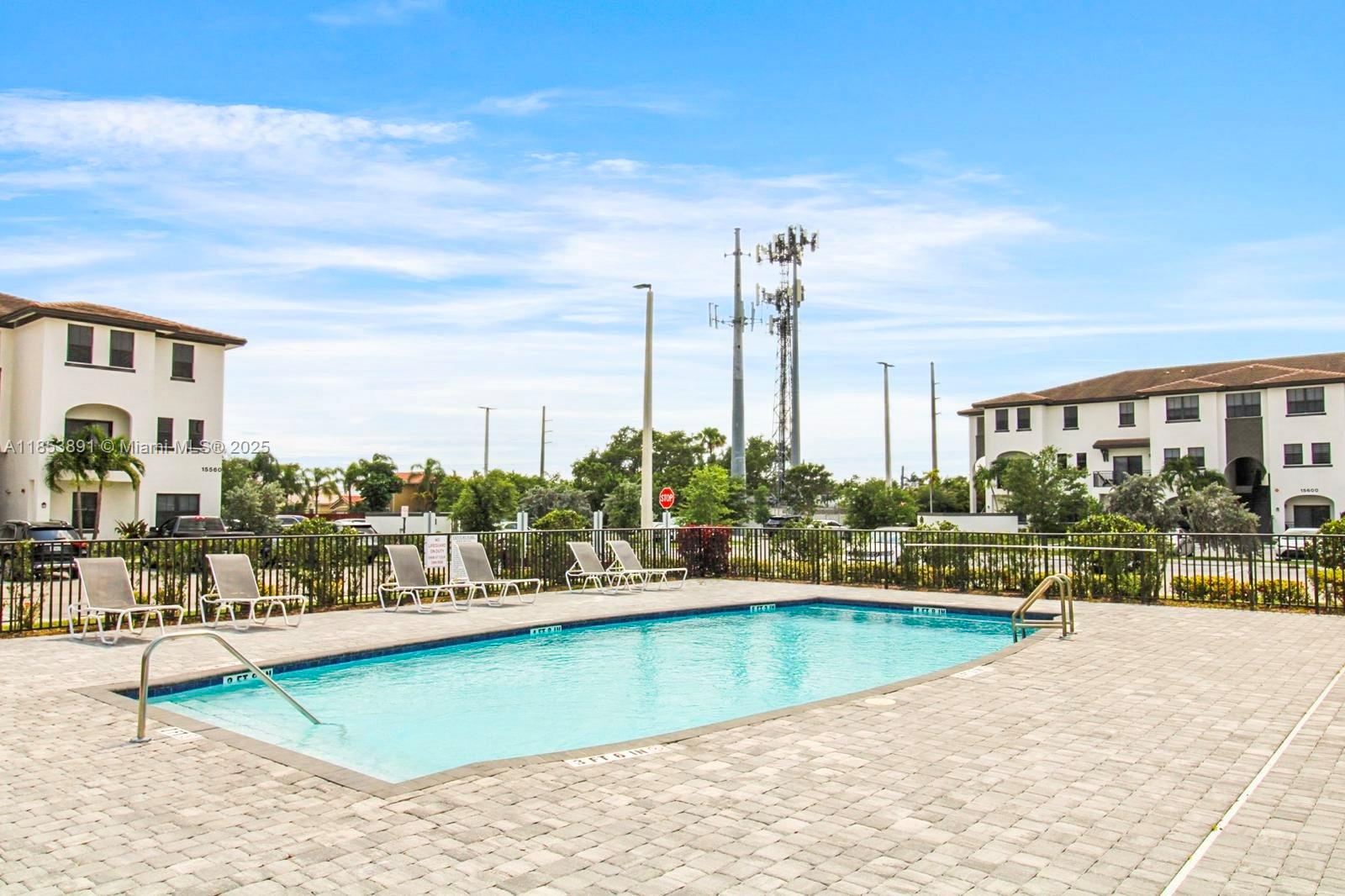 15560 Southwest 136th Street, Unit 3206 Miami, FL 33196 - Photo 17 of 18 a view of a swimming pool and a chairs
