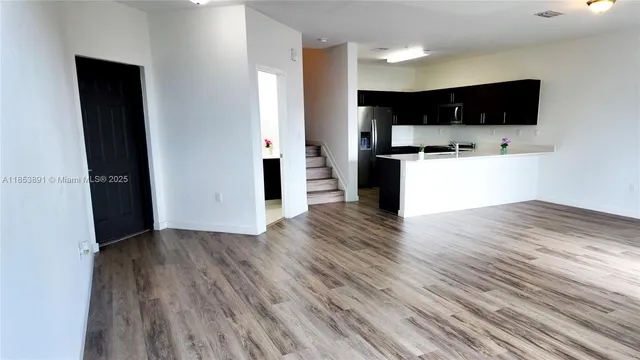 a view of kitchen with microwave and refrigerator