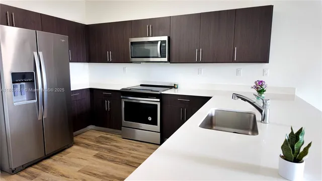 a kitchen with stainless steel appliances a stove a microwave and a refrigerator