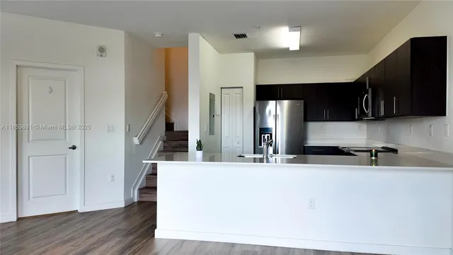 a view of a kitchen with a sink and a refrigerator