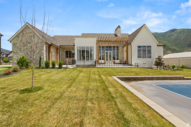 478 South Maple Lakes Drive Mapleton, UT 84664 - Photo 41 of 51 Expansive rear exterior featuring a stone and stucco facade, a pergola-covered patio, and a dedicated sport court