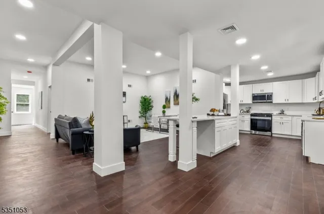 a large white kitchen with white cabinets and stainless steel appliances