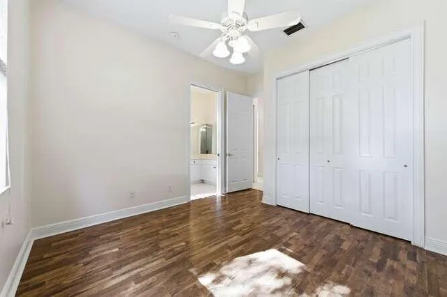 a view of an empty room with closet and a window