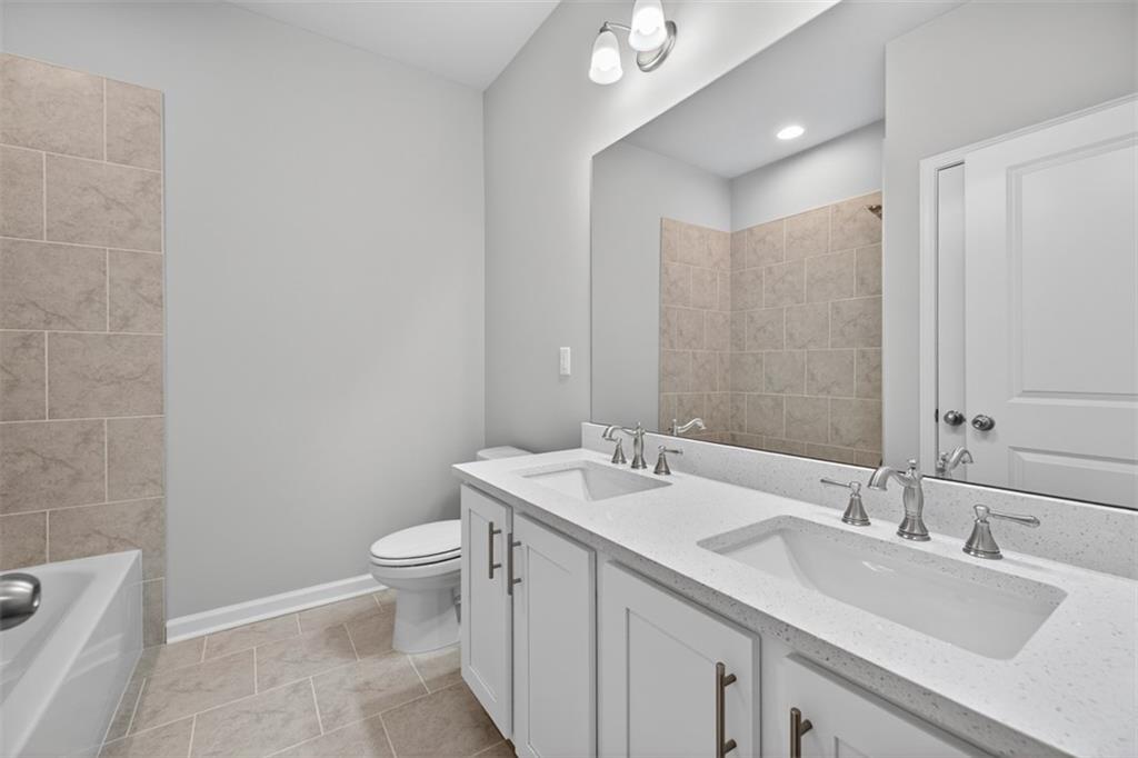 8845 Jot Em Down Road Gainesville, GA 30506 - Photo 43 of 87 a bathroom with a sink a toilet and a mirror
