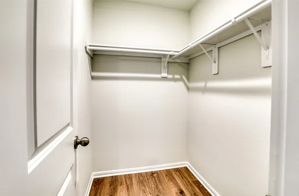 a view of walk in closet with empty racks