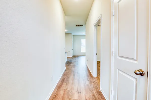 a view of a hallway with wooden floor and staircase