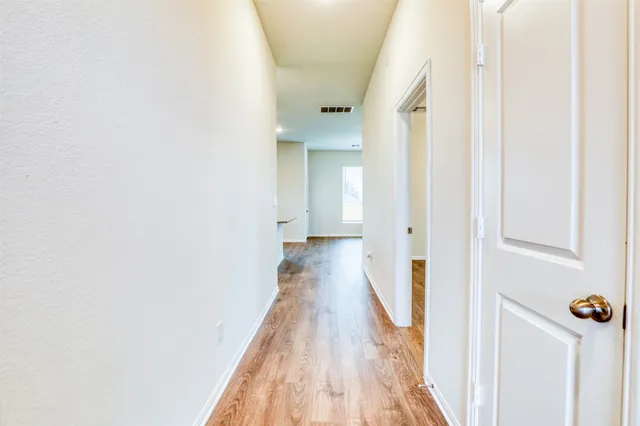 a view of a hallway with wooden floor and staircase
