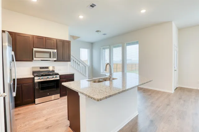 a kitchen with stainless steel appliances granite countertop a sink stove and refrigerator