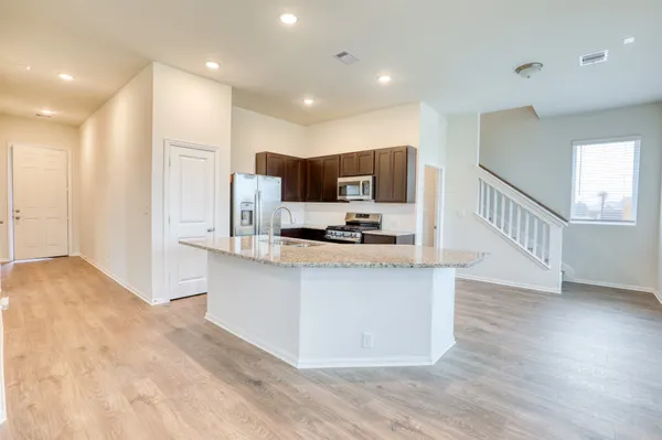 a open kitchen with stainless steel appliances granite countertop a stove a sink and a refrigerator
