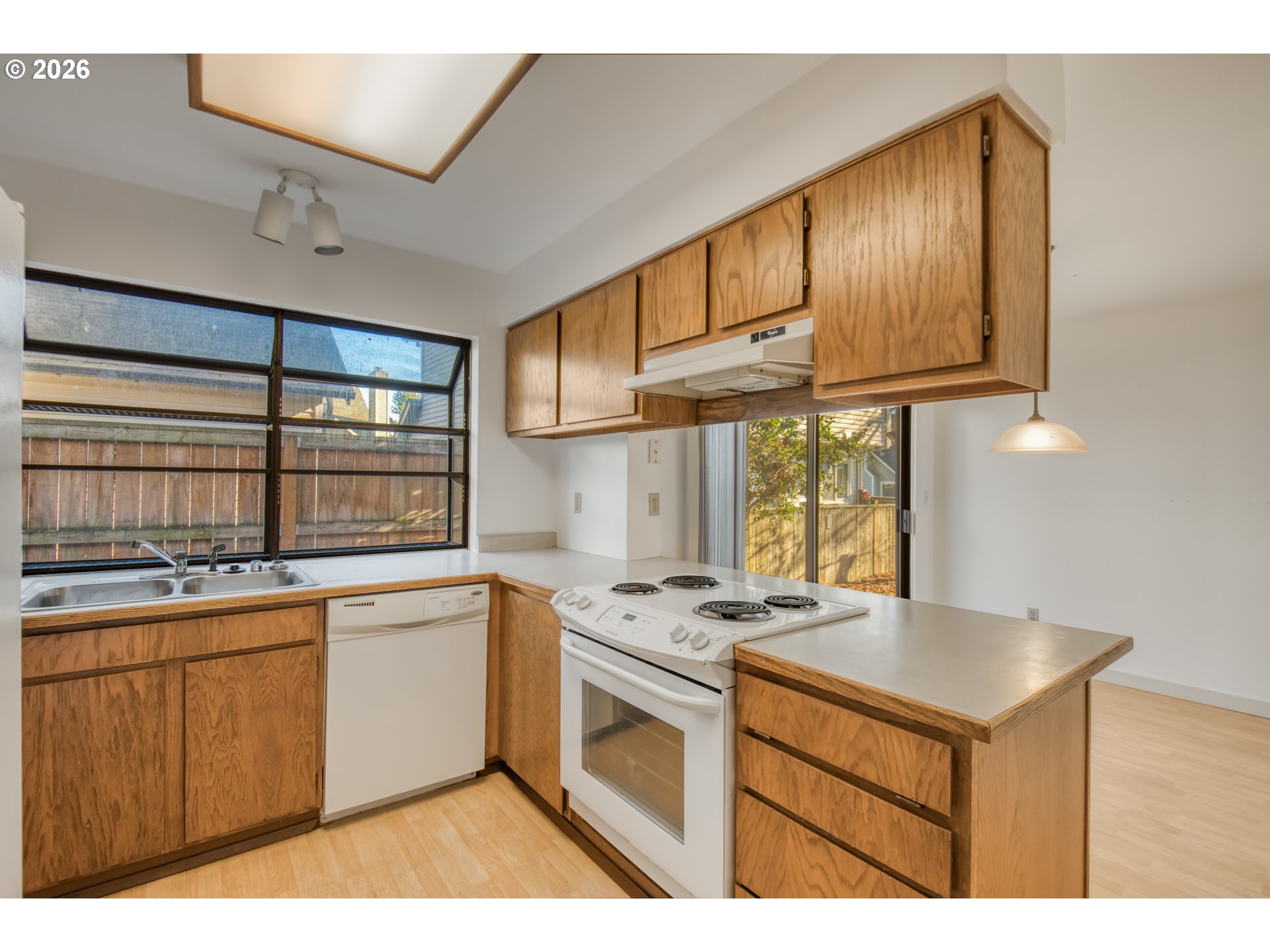 9731 Southwest London Court Portland, OR 97223 - Photo 11 of 27 a kitchen with stainless steel appliances granite countertop a stove a sink dishwasher and cabinets with wooden floor