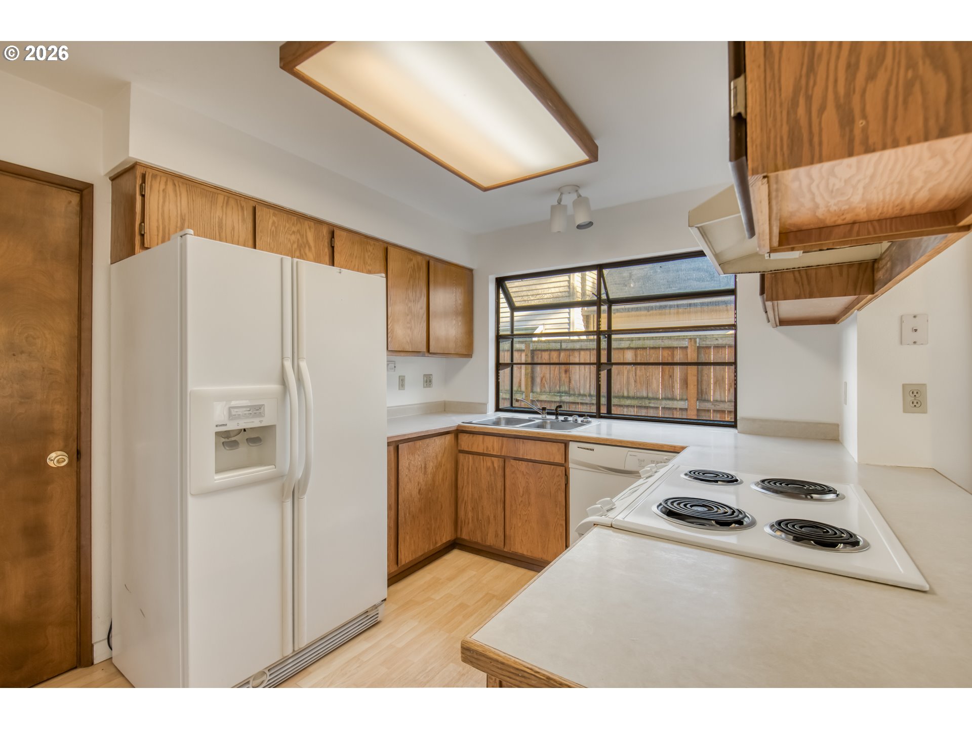 9731 Southwest London Court Portland, OR 97223 - Photo 10 of 27 a kitchen with stainless steel appliances granite countertop a refrigerator a sink and white cabinets