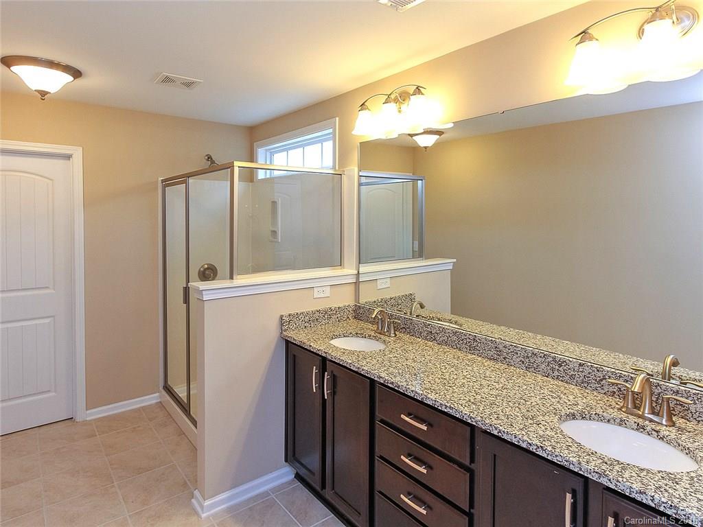 233 Annatto Way, Unit 553 Tega Cay, SC 29708 - Photo 11 of 22 a bathroom with a granite countertop sink and a mirror
