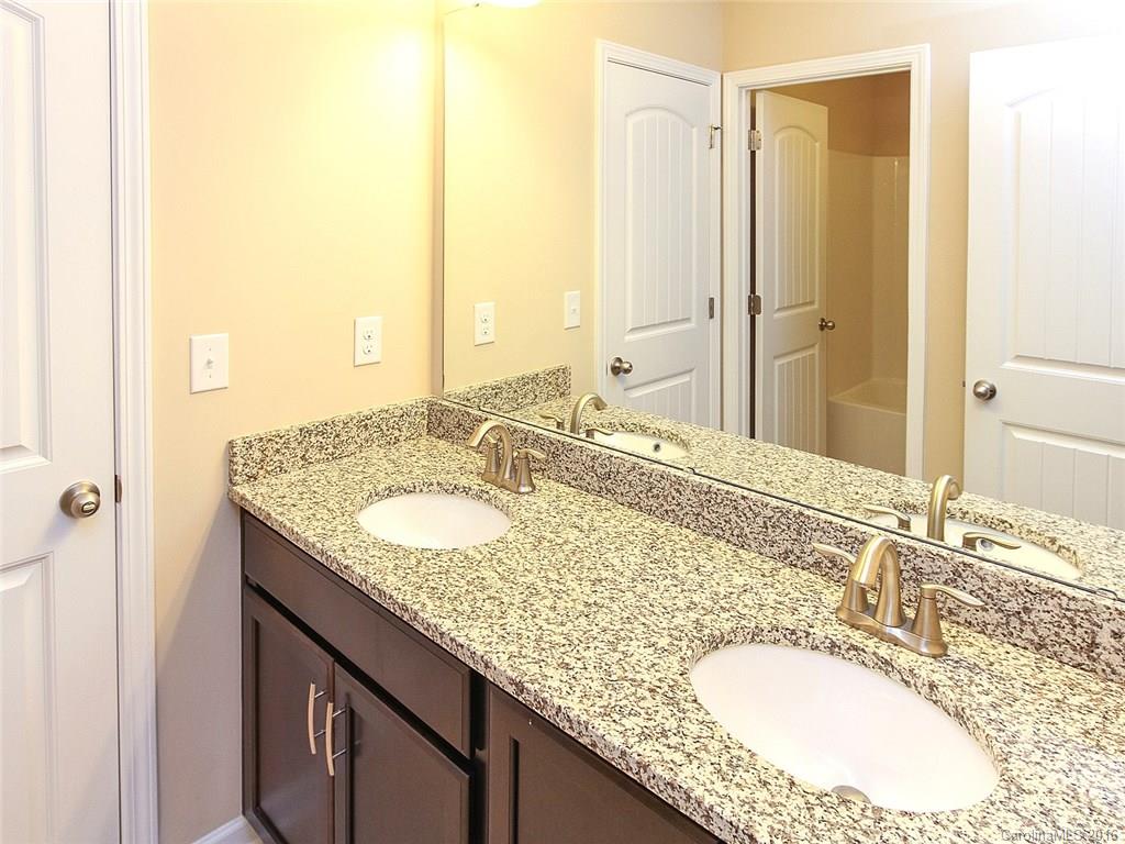 233 Annatto Way, Unit 553 Tega Cay, SC 29708 - Photo 13 of 22 a bathroom with a granite countertop sink and a mirror