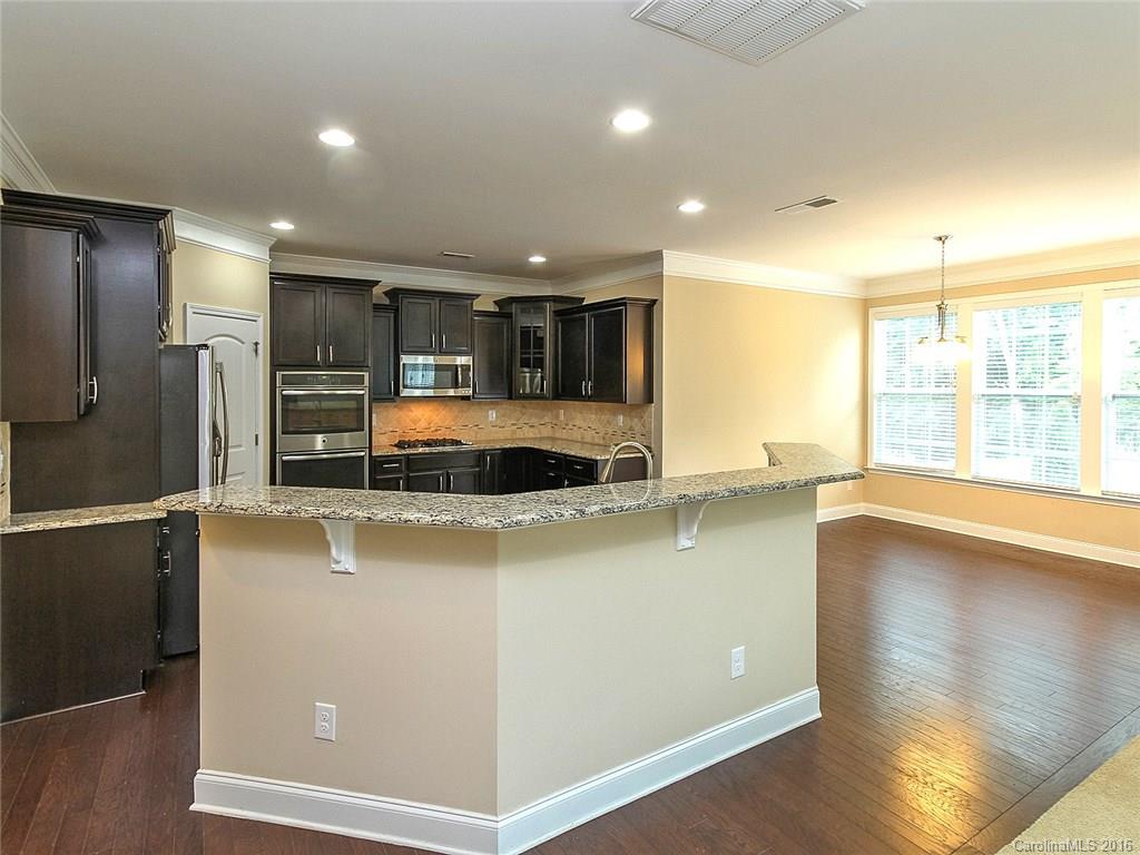 233 Annatto Way, Unit 553 Tega Cay, SC 29708 - Photo 5 of 22 a large kitchen with stainless steel appliances a large counter top and a stove