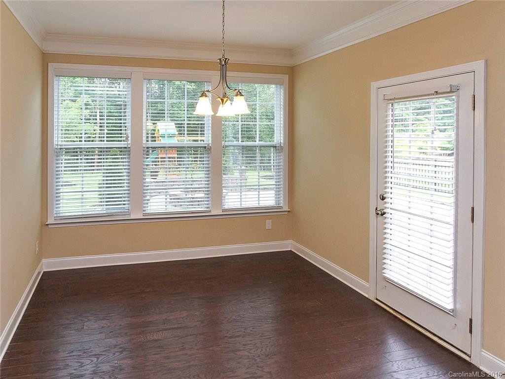 233 Annatto Way, Unit 553 Tega Cay, SC 29708 - Photo 9 of 22 a view of an empty room with wooden floor and a window