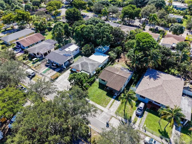 an aerial view of residential house with outdoor space and trees all around