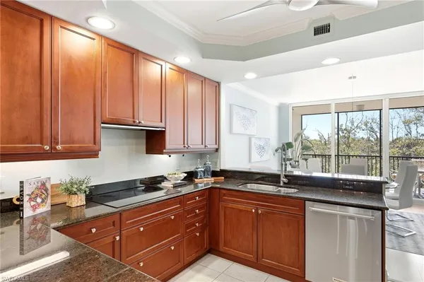 a kitchen with granite countertop a sink a counter space and cabinets