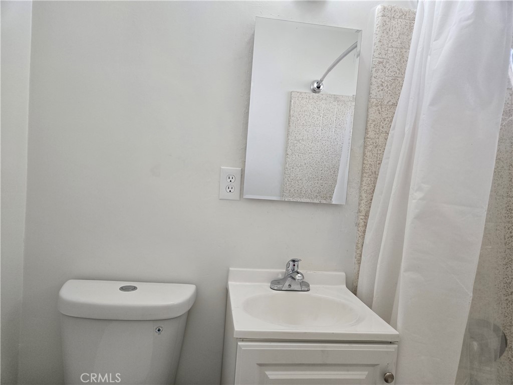 1734 Atchison Street Pasadena, CA 91104 - Photo 16 of 19 a bathroom with a toilet a sink and mirror