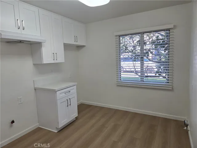 a view of a hallway with wooden floor and closet area