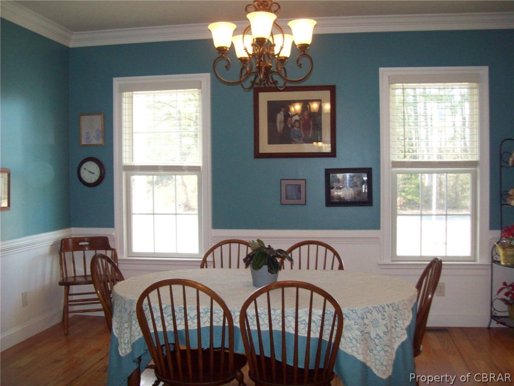 672 Lillys Neck Road Moon, VA 23119 - Photo 24 of 49 a view of a dining room with furniture a chandelier and wooden floor