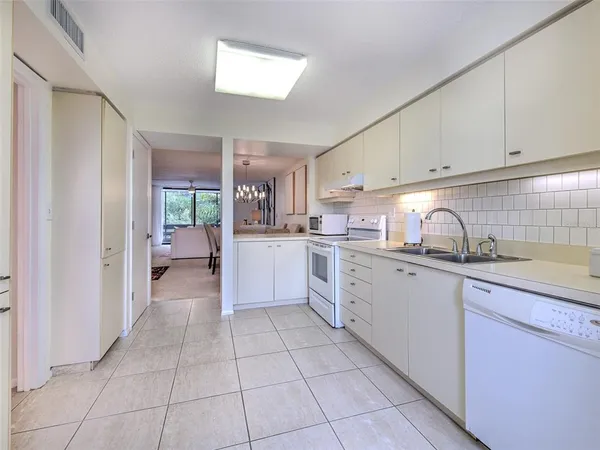 a kitchen with white cabinets and counter space
