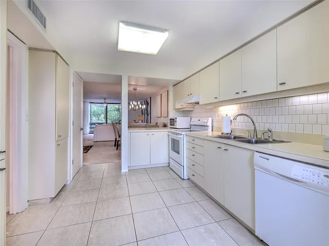 a kitchen with white cabinets and counter space