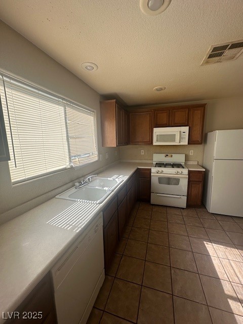 6240 Senegal Haven Street North Las Vegas, NV 89081 - Photo 3 of 5 Kitchen with stove, refrigerator, light countertops, dark tile patterned flooring, and dishwashing machine