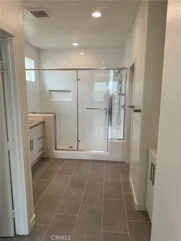 a bathroom with a glass door shower a sink and a mirror