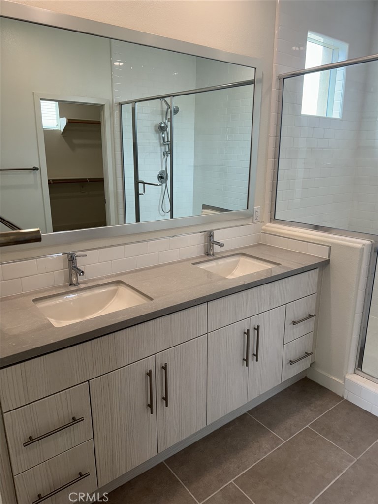 233 Radial Irvine, CA 92618 - Photo 15 of 27 a bathroom with a double vanity sink and mirror