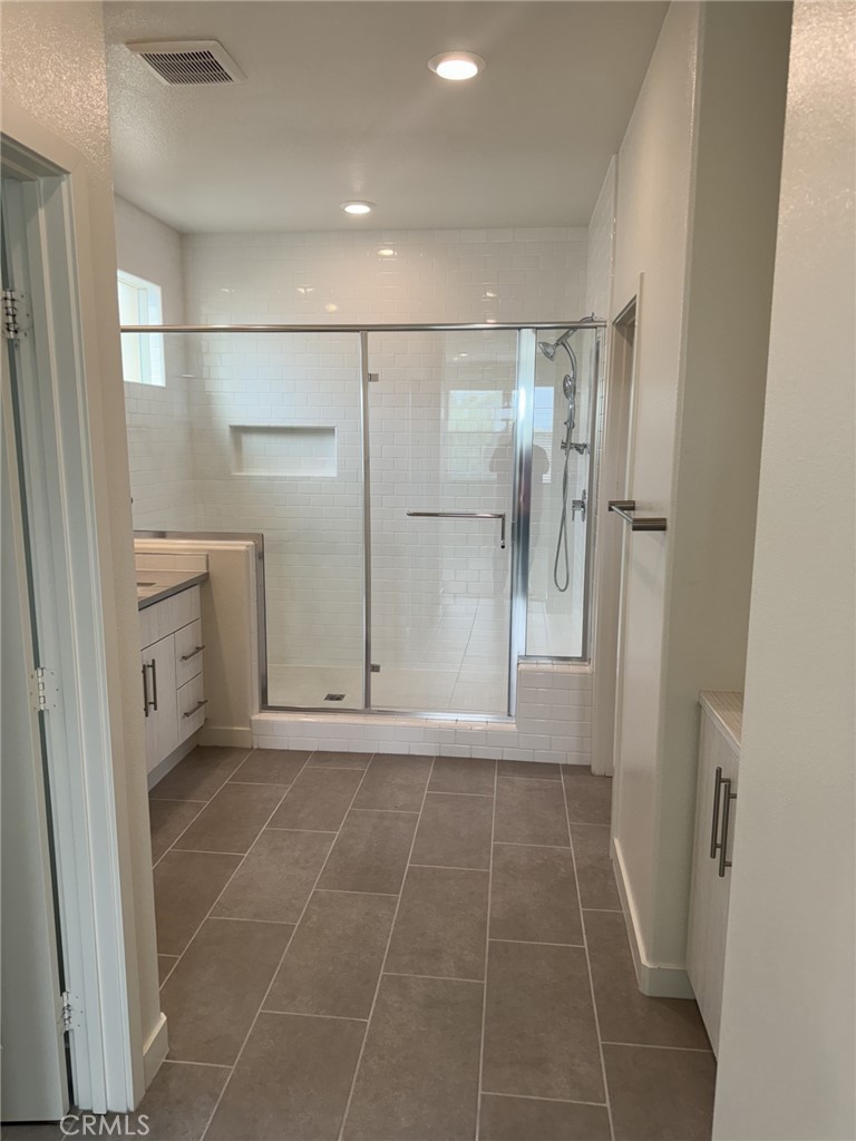 233 Radial Irvine, CA 92618 - Photo 16 of 27 a bathroom with a glass door shower a sink and a mirror