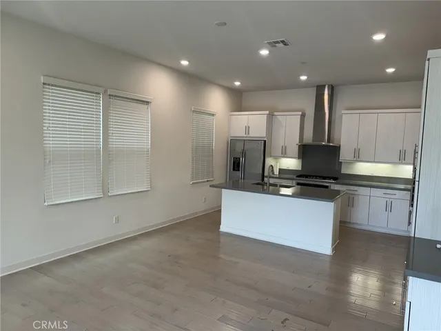 a large white kitchen with kitchen island a sink a stove and a refrigerator