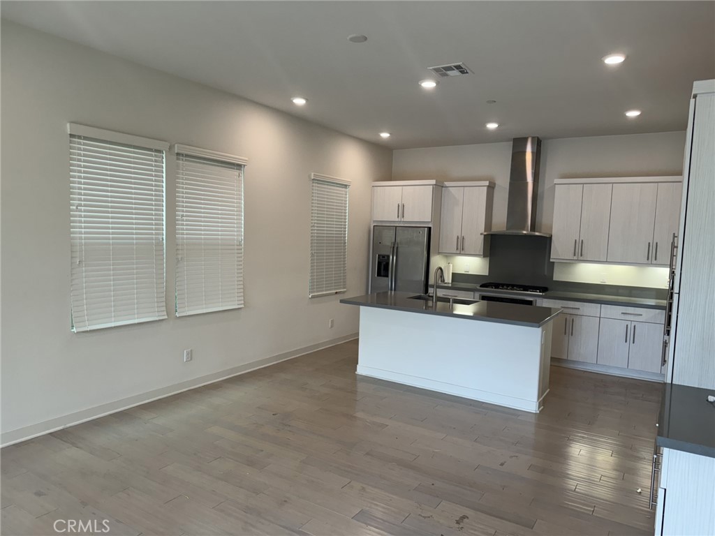 233 Radial Irvine, CA 92618 - Photo 4 of 27 a large white kitchen with kitchen island a sink a stove and a refrigerator