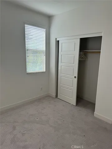 an empty room with closet and a window
