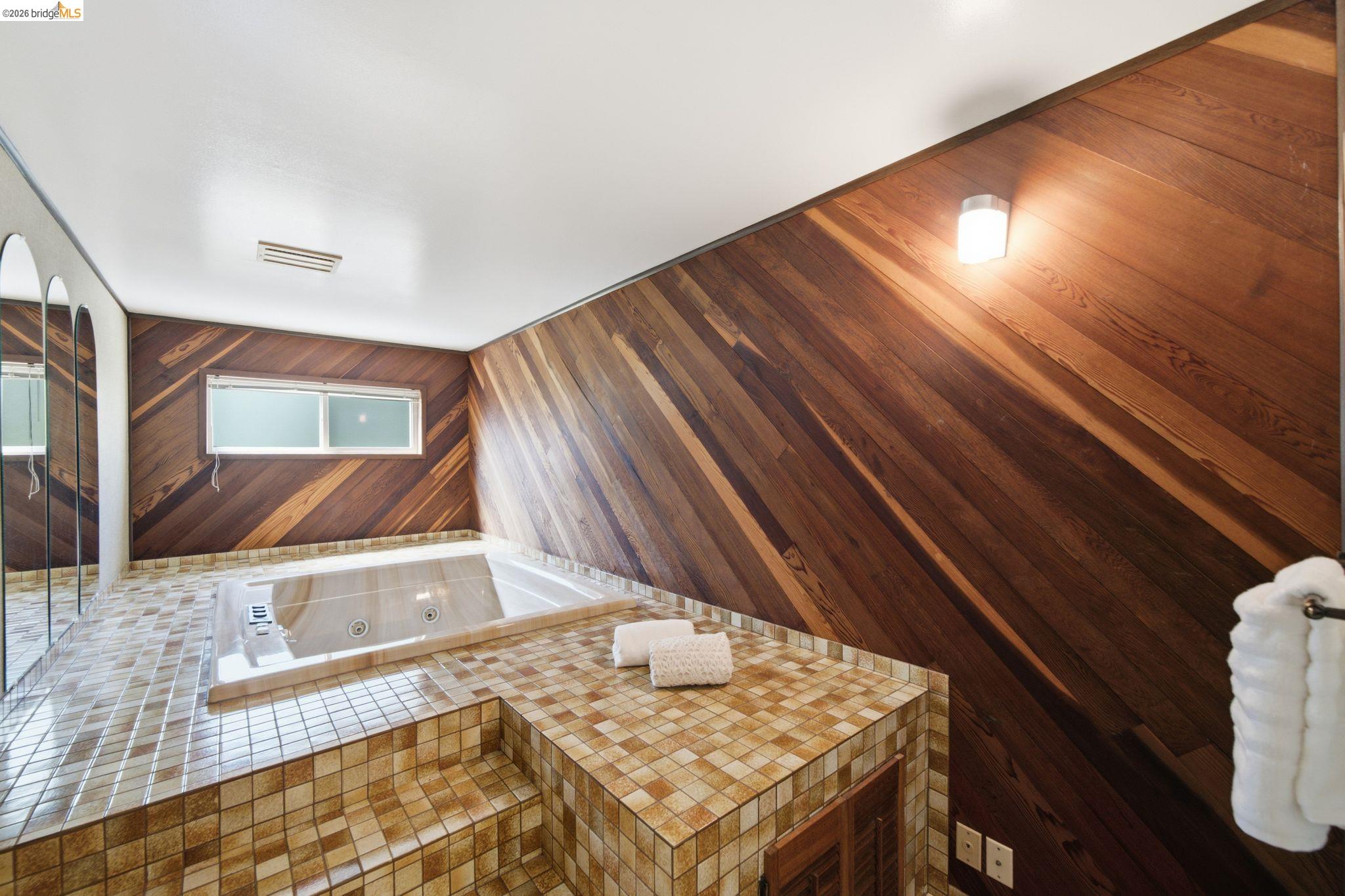 11133 Golf Links Road Oakland, CA 94605 - Photo 24 of 57 Recessed jetted tub surrounded by mosaic tile steps and platform