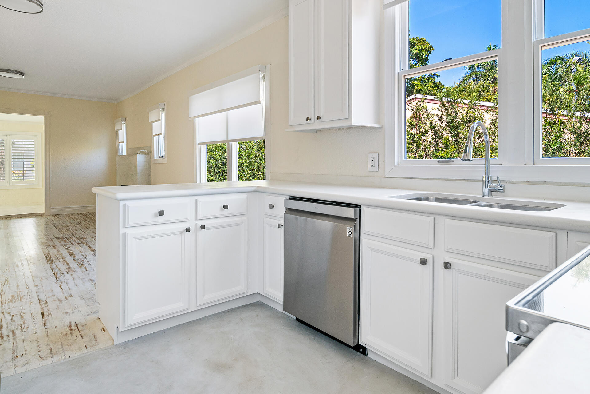 813 Avon Road West Palm Beach, FL 33401 - Photo 11 of 43 a kitchen with white cabinets white appliances and a window