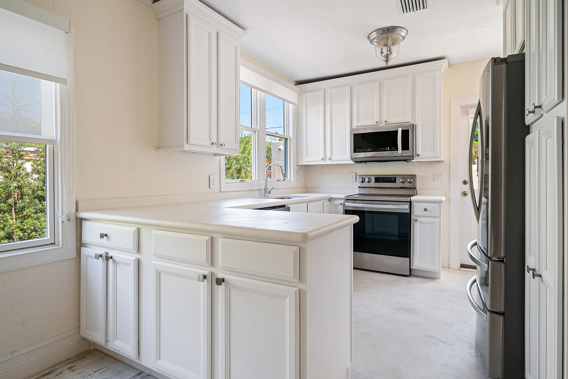 813 Avon Road West Palm Beach, FL 33401 - Photo 13 of 43 a kitchen with kitchen island white cabinets and refrigerator