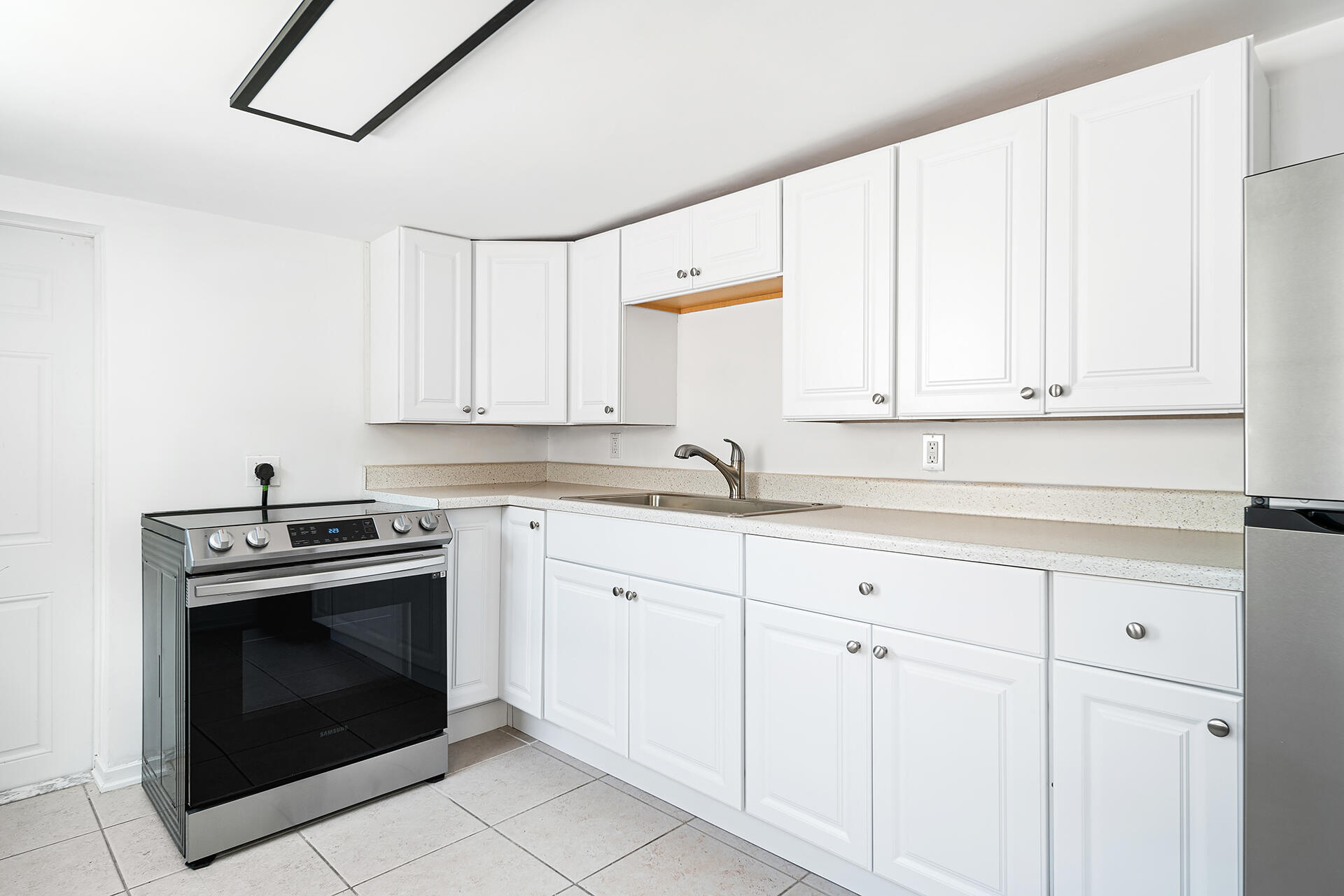 813 Avon Road West Palm Beach, FL 33401 - Photo 33 of 43 a kitchen with granite countertop white cabinets stainless steel appliances and sink