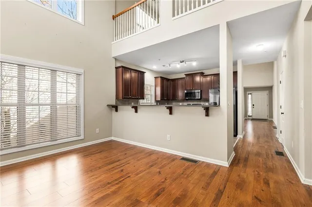 a view of a hallway with wooden floor and closet